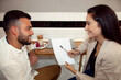 © Sophiaarenasphoto - Pareja revisando su trabajo. Pareja mirándose. hombre y mujer revisando folios.  Chico mirando a chica. Chica sonriendo a chico. Reunión de negocios. Entrevista de trabajo.