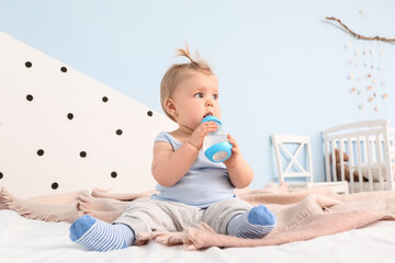 Sticker - Cute baby girl drinking water from bottle in bedroom