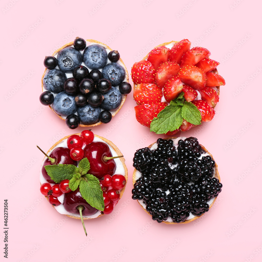 Tasty berry tartlets on pink background