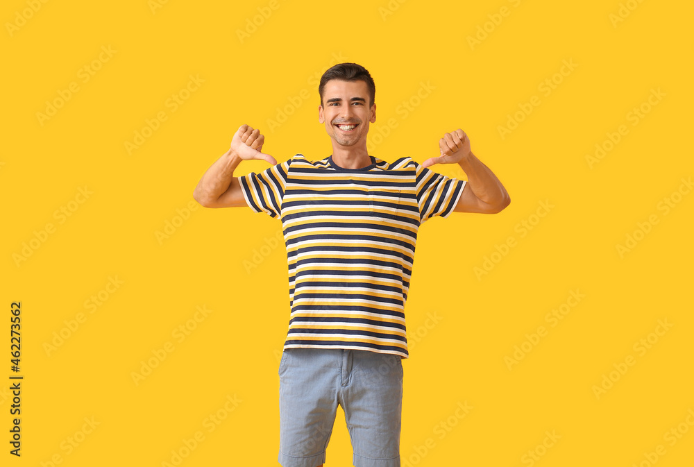 Handsome young man in stylish t-shirt on color background