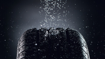 Car tire with splashing water in detail