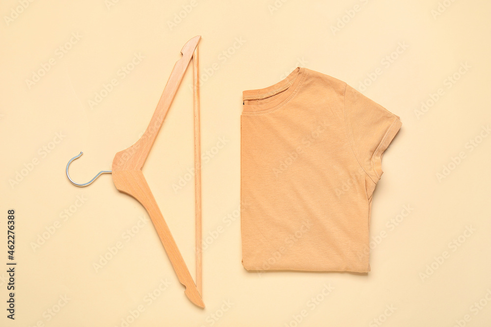 Stylish t-shirt and hanger on color background