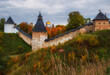 Powerful defensive walls and beautiful churches on the hills in the Dormition Pskovo Pechersky Monastery in the city of Pechery, Pskov Region, Russia during the golden autumn