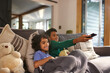 © Southworks - Two cheerful boys watching TV using remote control