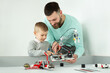 © Artem Zakharov - Young father and son create a robot in a robotics club.