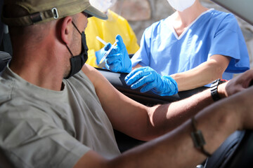 Close-up of a mature male being vaccinated in a self-service