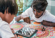 © Karlos Garciapons - top view of two multi-ethnic boys playing chess. the boys are of Chinese and Indian origin.