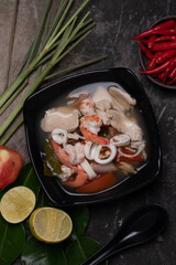 Wall Mural - Tom Yum, Clear Soup, Chicken, Shrimp, Squid, popular Thai food mixed boiled lime, chili, mushroom, lemongrass, herbs