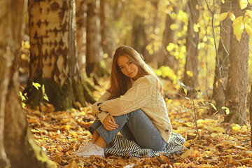 Wall Mural - girl sitting autumn park, autumn season september in the forest