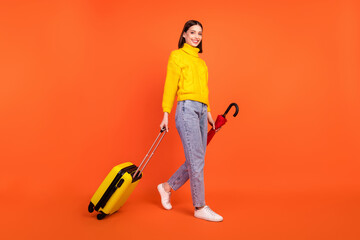 Wall Mural - Full length profile side photo of young woman happy smile go walk airport luggage travel isolated over orange color background