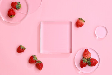 Wall Mural - Empty glass podium with strawberry extract on on pink background. Top view image. Production of cosmetics based on strawberry. 