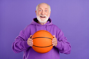 Poster - Portrait of attractive cheerful man holding in hands orange ball rest hobby isolated over bright violet purple color background