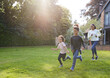 © Southworks - Family running on lawn outside house