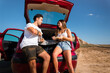 © Jorge Argazkiak - One woman and one man eating and chatting in a car while travelling at Bardenas Reales desert, Navarra, Basque Country.
