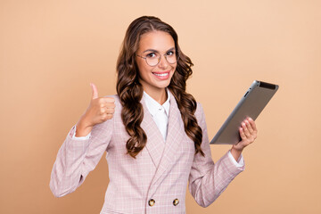 Poster - Portrait of cheerful candid lady show thumb up look camera isolated on beige color background