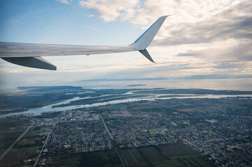 Wall Mural - View from airplane with crowded downtown and large river connected to the sea