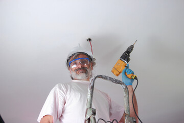 Wall Mural - Elderly Italian repairman on a ladder holding a drill