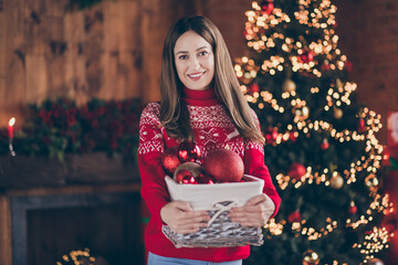 Wall Mural - Photo of adorable shiny young woman dressed red sweater decorating new year tree smiling indoors room home house