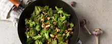 frying pan with stir fry with broccoli and cashews on the table