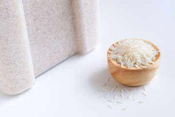 Jasmine rice in measuring wooden bowl and grain pile, Container or Plastic box on white background, Keep dried storage and Agricultural organic produce, Staple food with carbohydrate of Asian people.