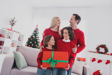 Wall Mural - Portrait of careful beautiful handsome cheerful family hugging holding giftbox congrats festal eve at home house indoors