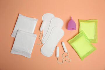 Wall Mural - Menstrual pads and other period products on pale orange background, flat lay