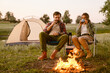 © Drobot Dean - White couple smiling and drinking tea during camping together