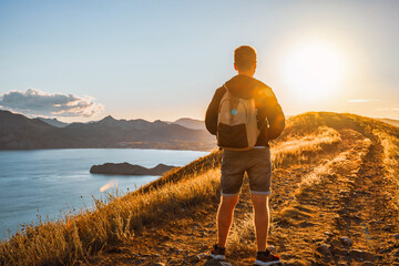 Wall Mural - Male silhouette at sunset on a mountain top. Sport travel and active life concept. Beauty world.