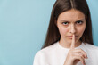 © Drobot Dean - Young brunette woman showing silence gesture at camera