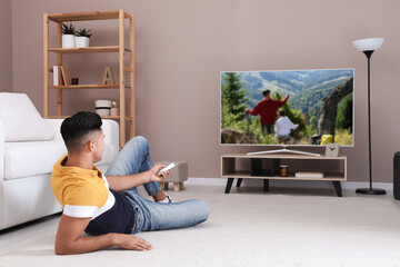 Wall Mural - Man watching television at home. Living room interior with TV on stand