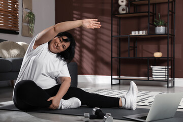 Sticker - Overweight mature woman stretching while watching online class at home