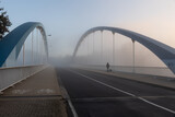 Fototapeta Most - Brücke im Nebel auf der ein Mann und ein Hund geht