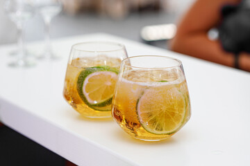 A cocktail glass of gin and tonic soda garnished by the lemon slice.