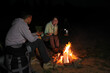 © New Africa - Couple near bonfire outdoors in evening. Camping season