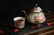 afternoon tea image with black tea and beautiful teapot and cup on board