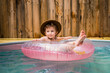 © Cavan Images - Little boy in cowboy hat cooling off in a backyard pool.