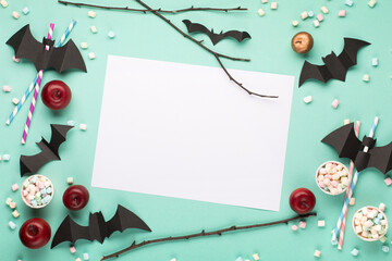 Halloween decorations and black bats on green mint paper background. Halloween holiday concept. Flat lay, top view.