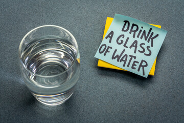 Wall Mural - drink a glass of water - hydration reminder, handwriting on blue sticky note