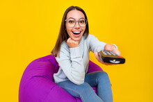 Photo Of Cheerful Amazed Young Woman Tv Switch Channel Remote Control Isolated On Yellow Color Background