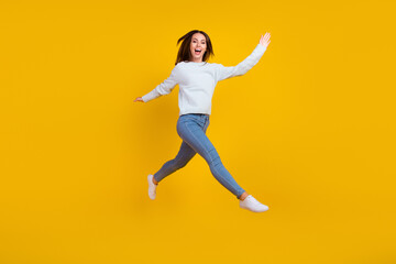 Poster - Full length photo of happy young woman jump up walk enjoy good mood isolated on yellow color background