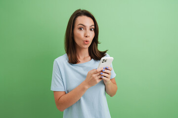 Wall Mural - Young woman expressing surprise while using cellphone