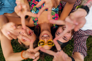 Wall Mural - happy young company of friends sitting park