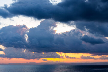 Wall Mural - Stunning dramatic, cloudy sunrise over a calm water. Natural background, Sardinia, Italy.