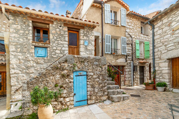 Wall Mural - A picturesque garden courtyard and alley in the medieval stone hilltop village of Gourdon in the Alpes-Maritimes mountains of Southern France.