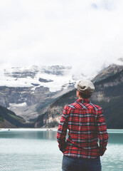 Wall Mural - Woman in red shirt from behind looking at lake and mountains