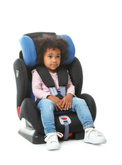 Canvas Print - Little African-American girl buckled in car safety seat on white background