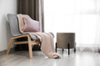 © Pixel-Shot - Plaid with pillow on stylish armchair near window in living room