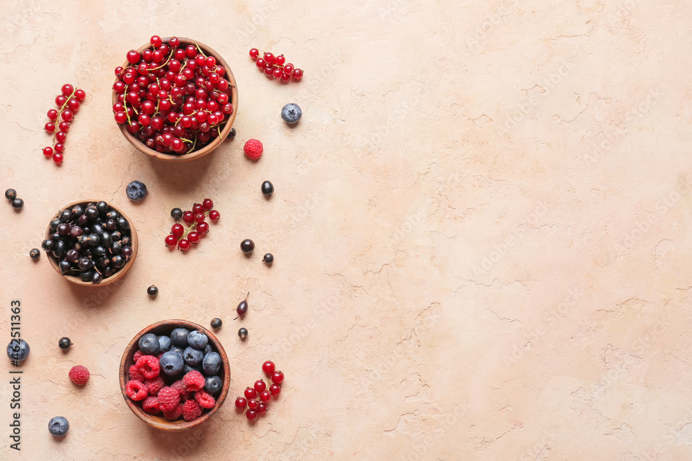 Bowls with different ripe berries on color background