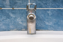 Dirty faucet with limescale, calcified water tap with lime scale on washbowl in bathroom