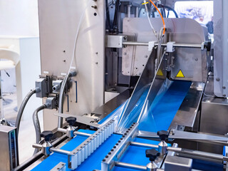 Poster - Packaging conveyor. Equipment for packaging products. Automated conveyor systems. Industrial automation for packaging. A line for wrapping products in polyethylene.